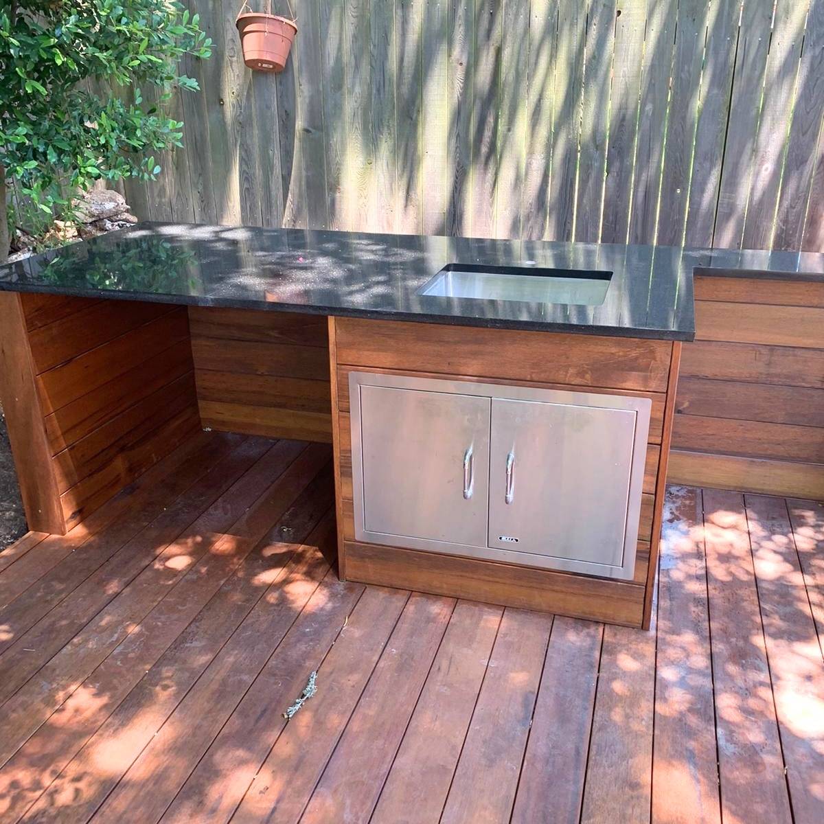 After: family-friendly Austin outdoor kitchen with deck, fridge, and seating area