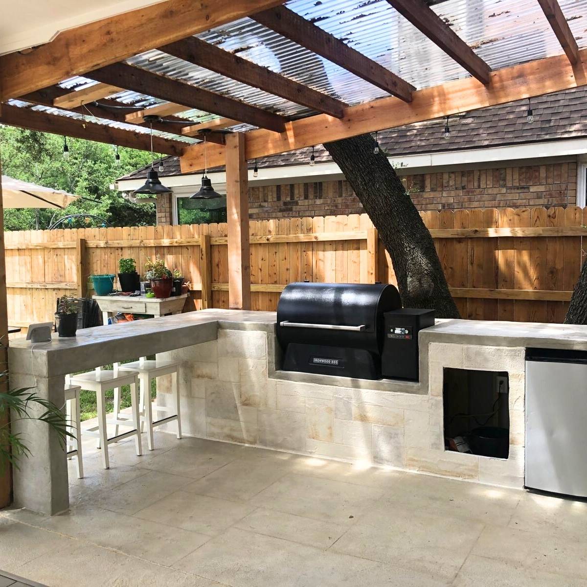 After: custom Austin outdoor kitchen with built-in seating, grill, and pergola