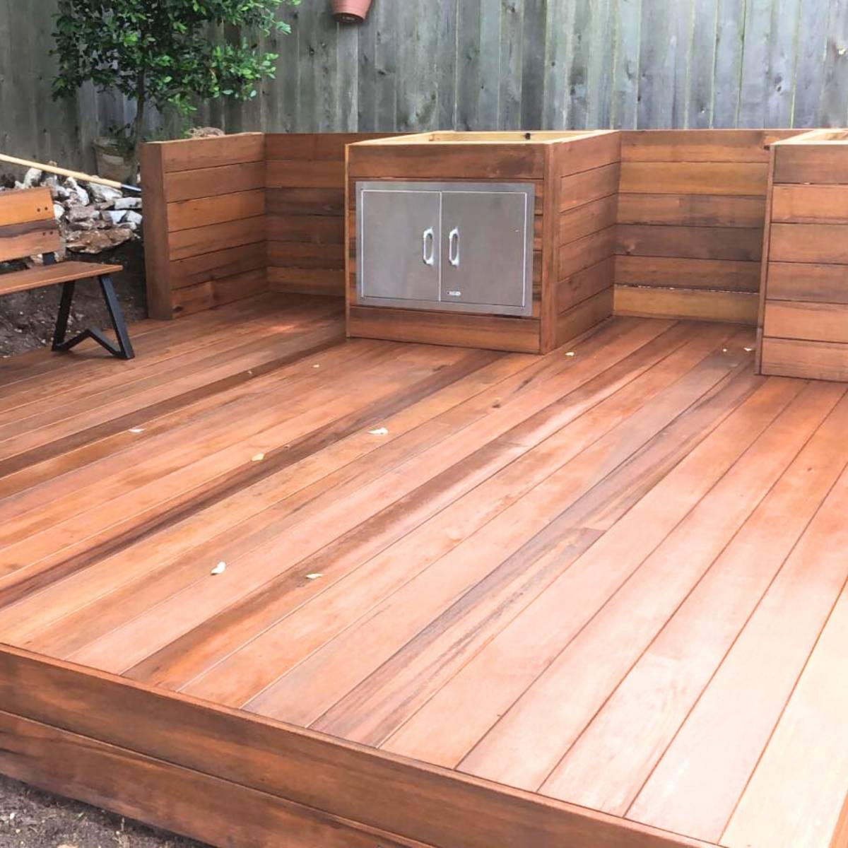 After: family-friendly Austin outdoor kitchen with deck, fridge, and seating area