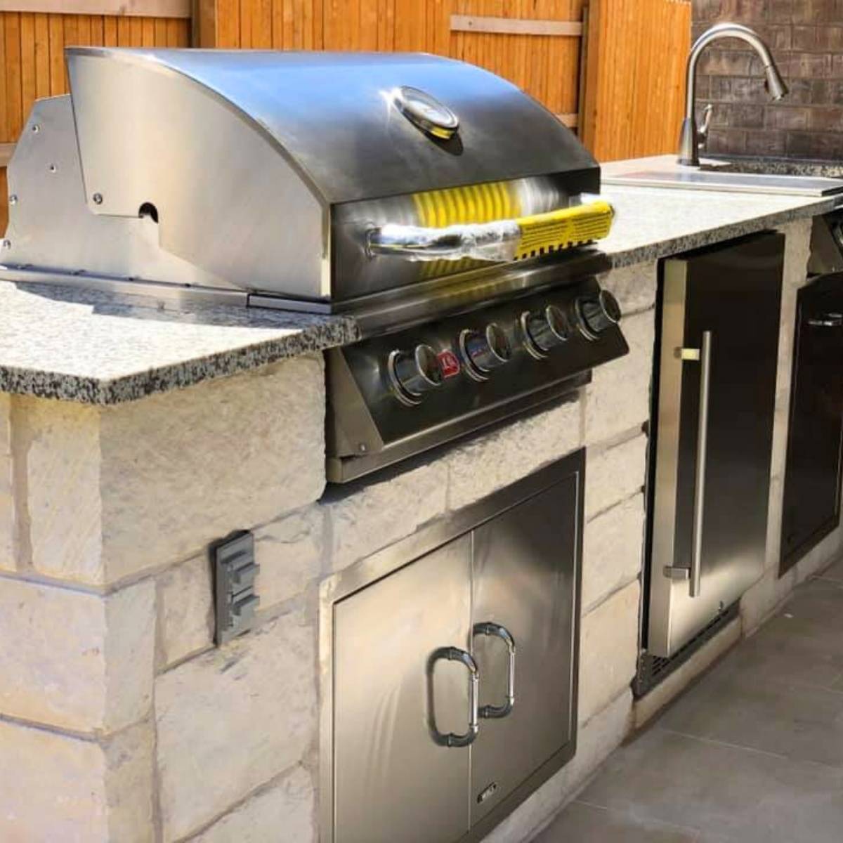 After: Austin backyard transformation featuring stone outdoor kitchen and grill