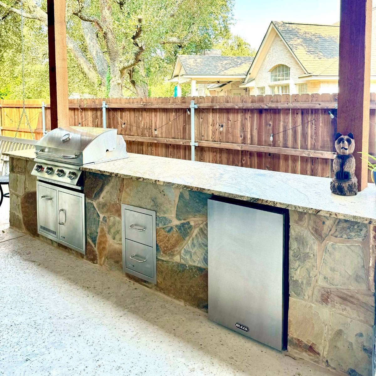 After: Austin backyard transformation featuring stone outdoor kitchen and grill