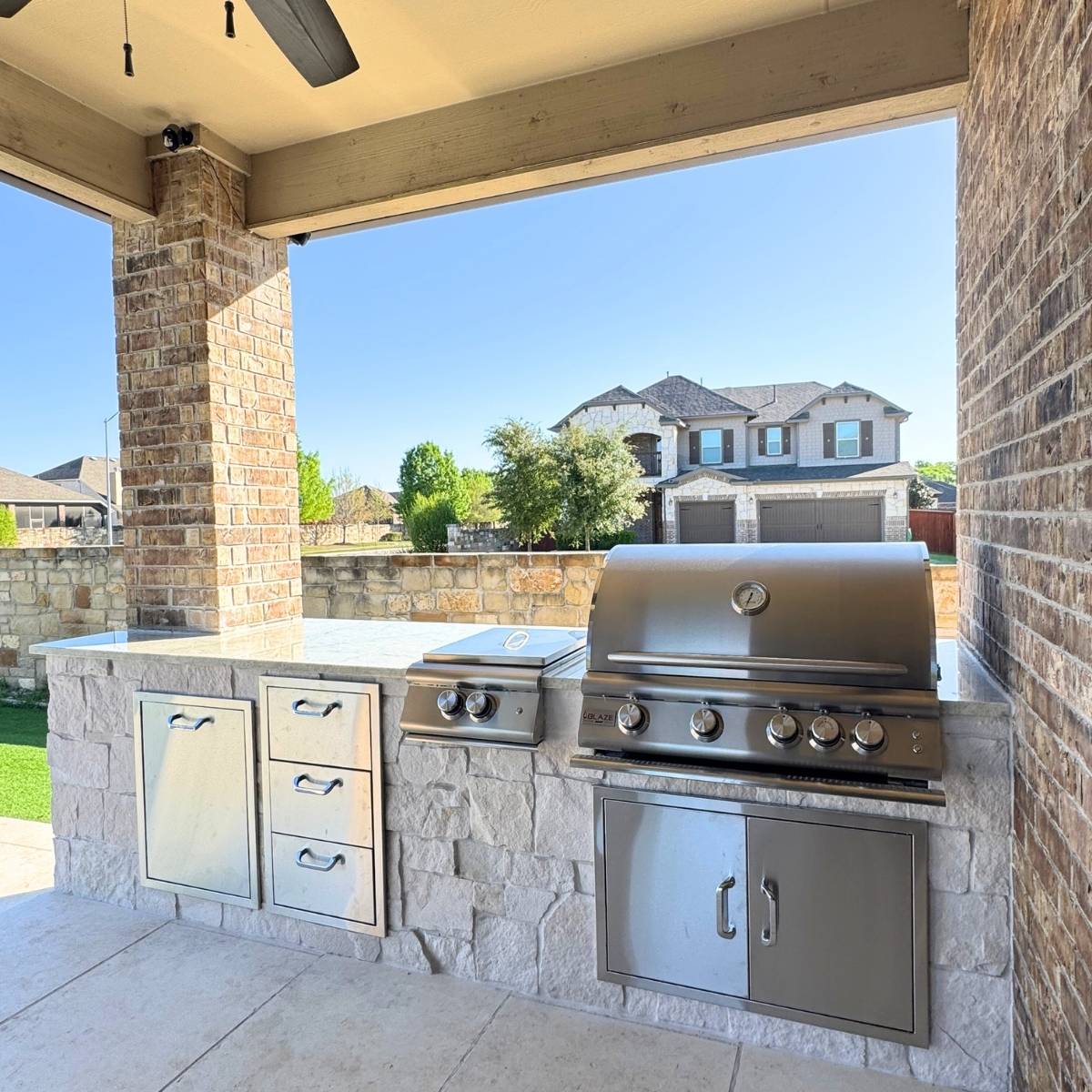 After: Austin outdoor kitchen remodel with stone counters and stainless appliances