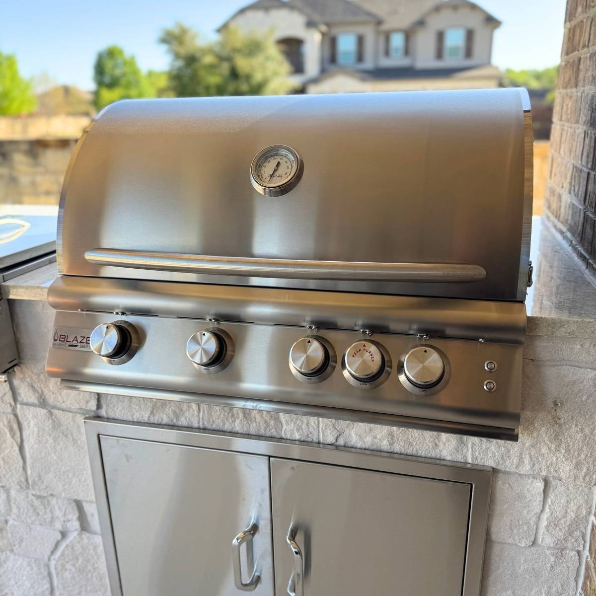 After: Austin outdoor kitchen remodel with stone counters and stainless appliances