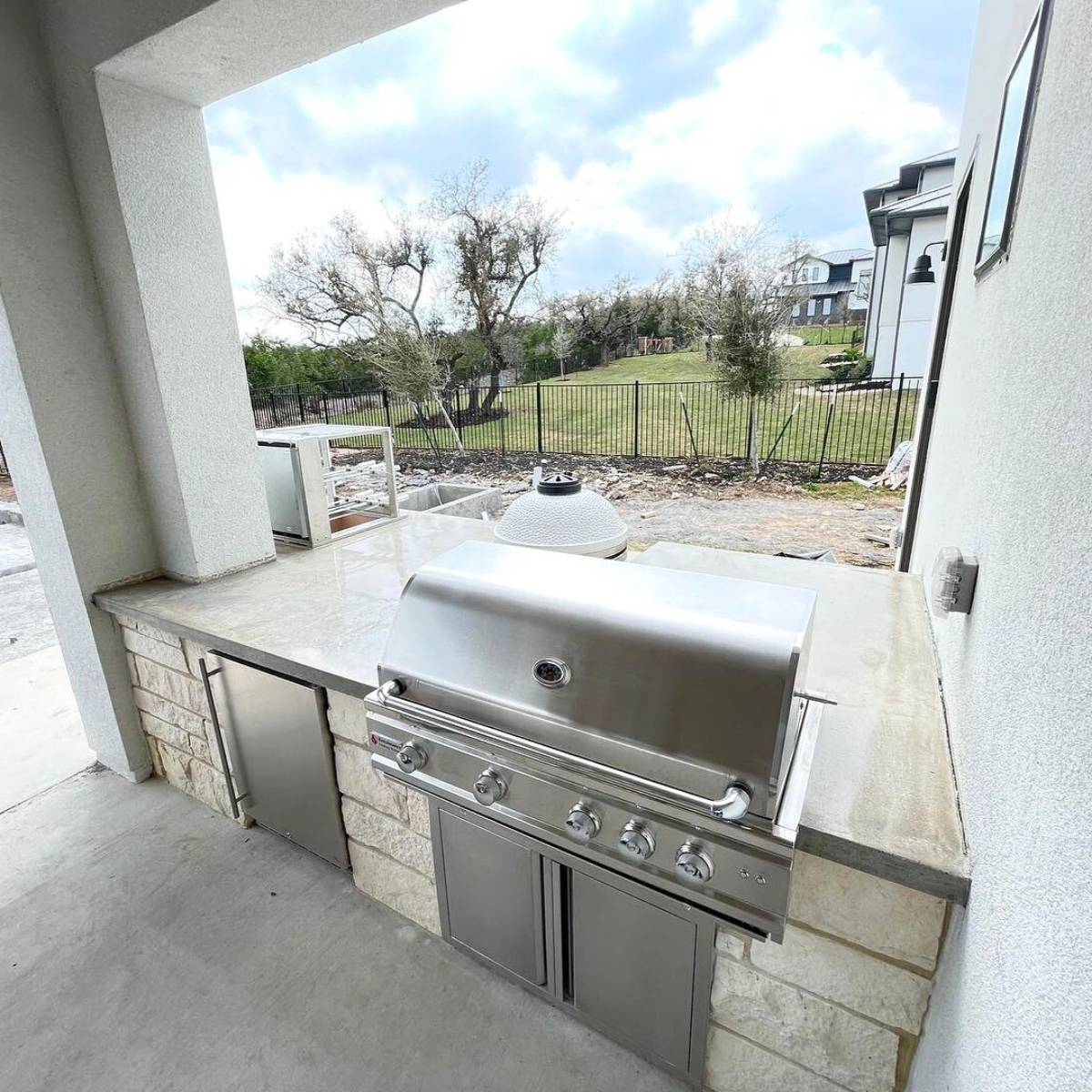 After: Austin backyard transformation featuring stone outdoor kitchen and grill