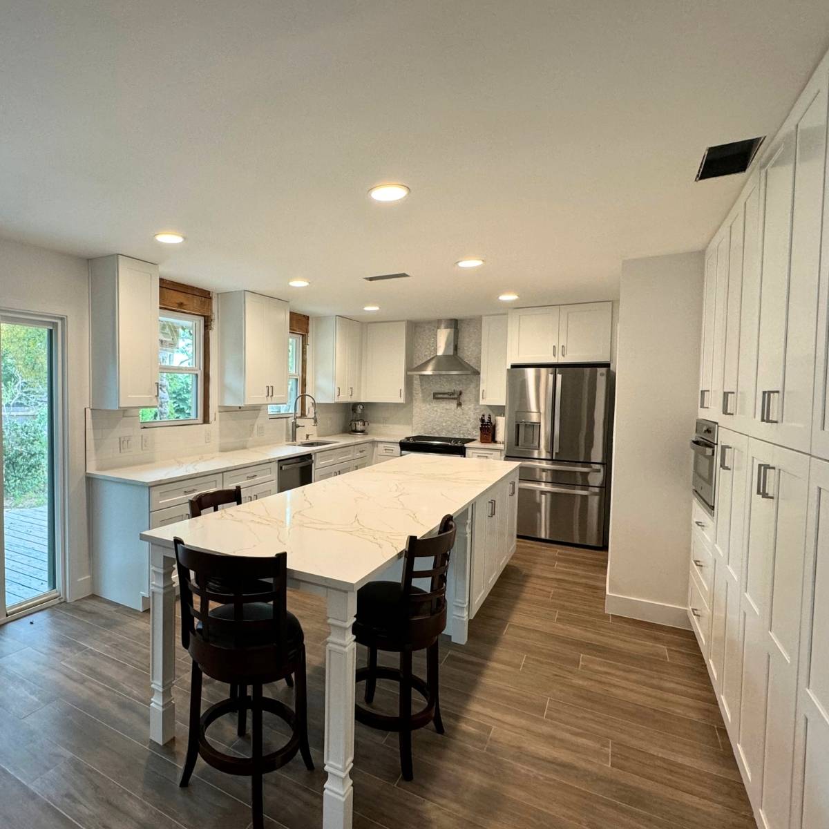 After: Modern Austin kitchen remodel by ATX Custom Remodel - white cabinets, wood accents and island seating