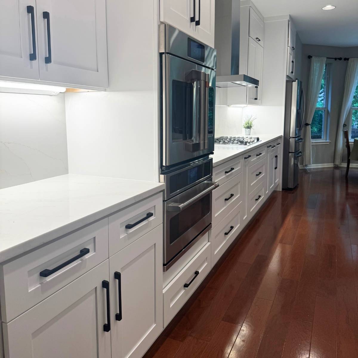 After: Bright modern Austin kitchen renovation - grey cabinets & large island with modern stainless steel appliances