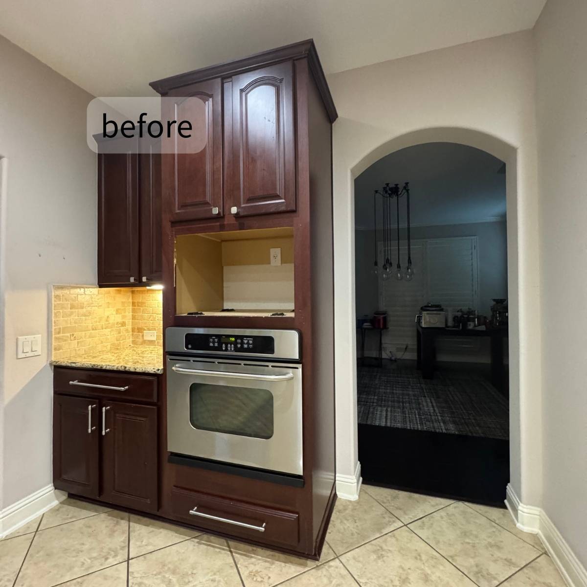 Before: Dated Austin kitchen with dark oak cabinets and small entrance