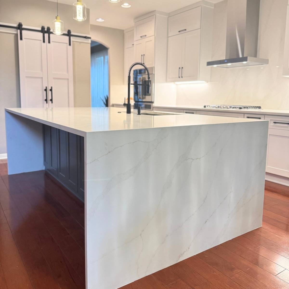 After: Bright modern Austin kitchen renovation - grey cabinets & large island with waterfall countertop