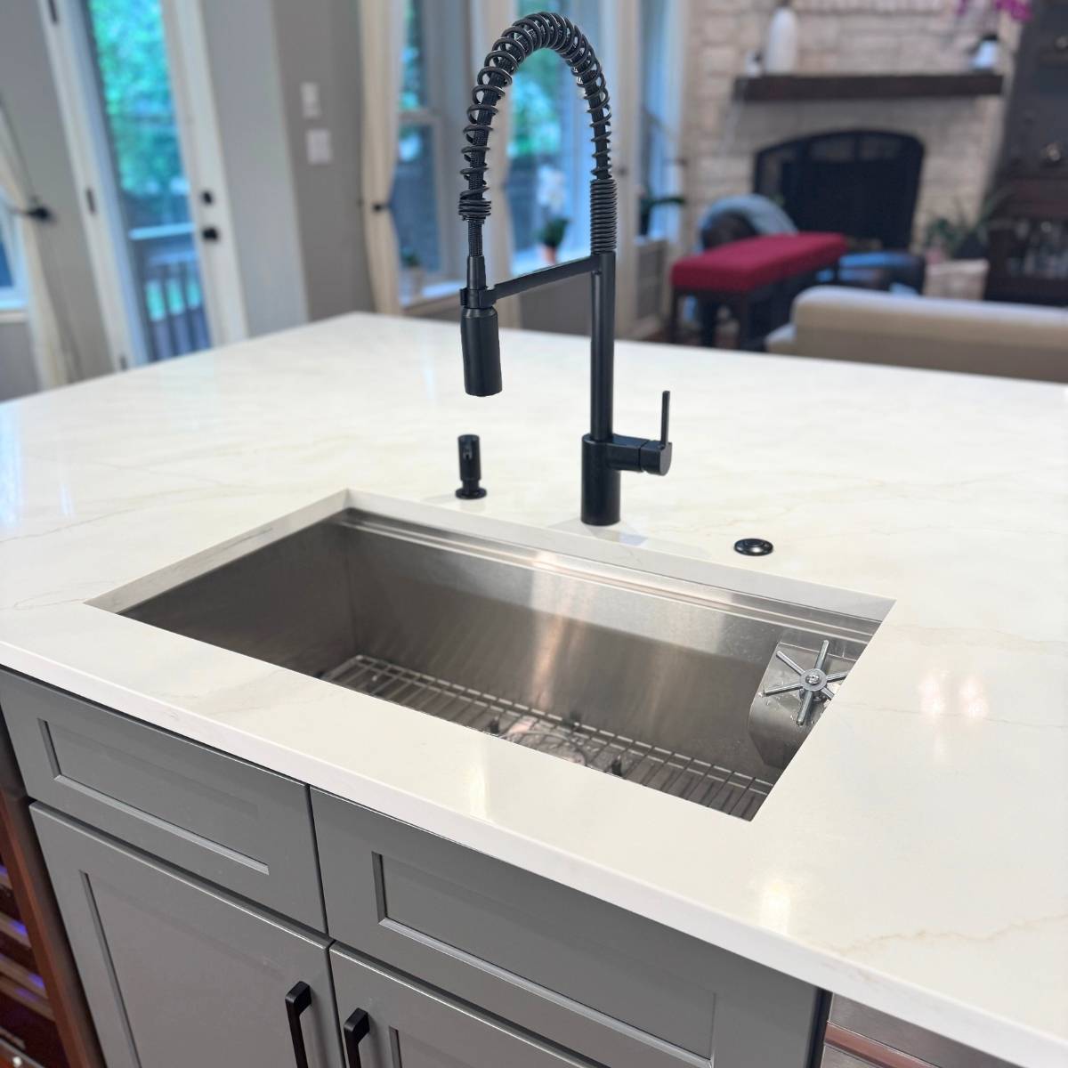 After: Bright modern Austin kitchen renovation - grey cabinets & large island with modern black fixtures