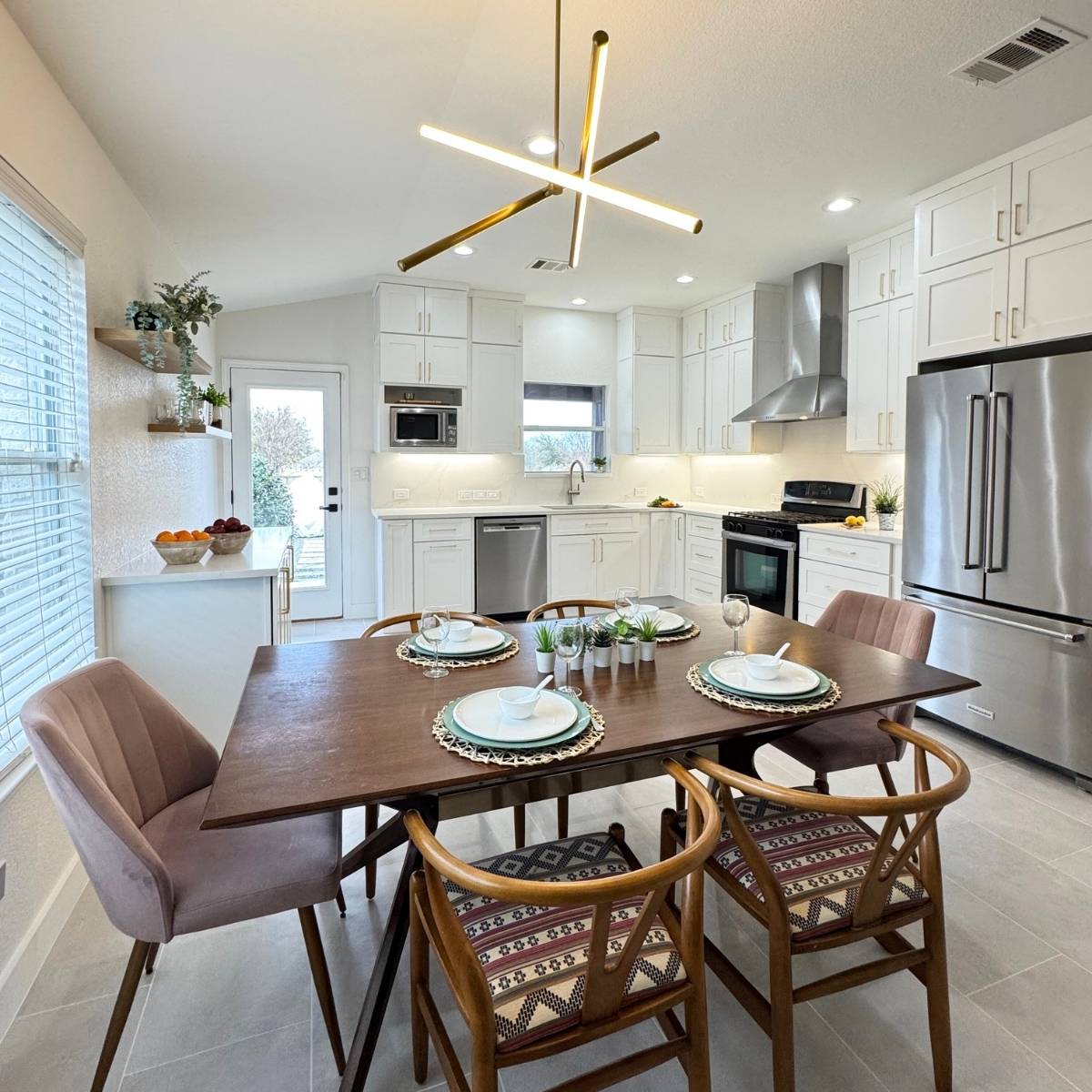 After: Open concept Austin kitchen transformation with white cabinets and stainless appliances