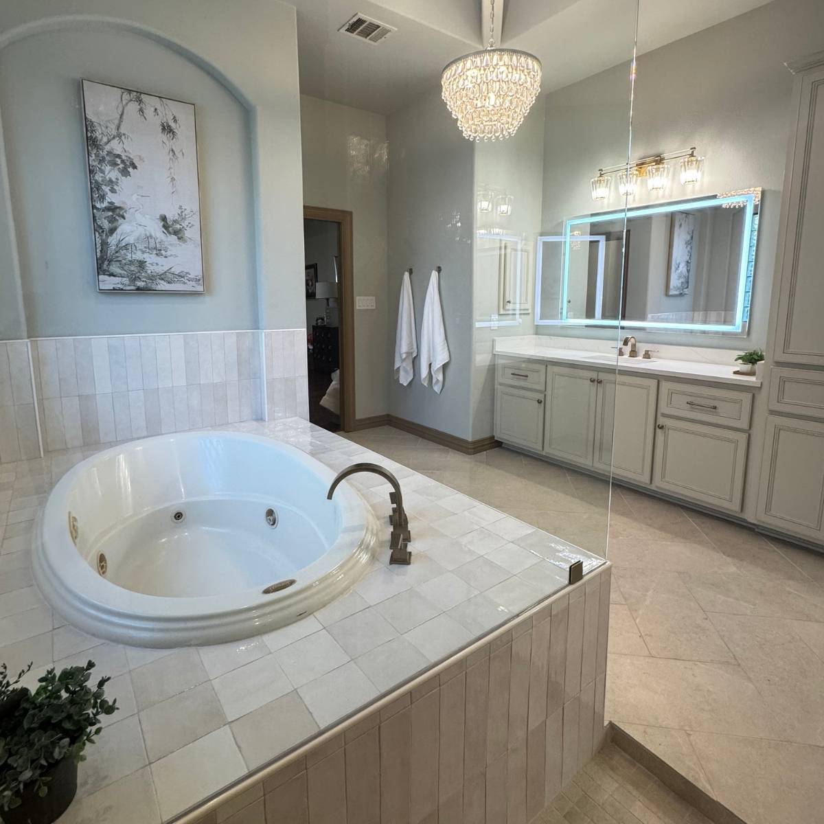After: Remodeled Austin bathroom after remodel with new vanities, light up mirror, & statement lighting