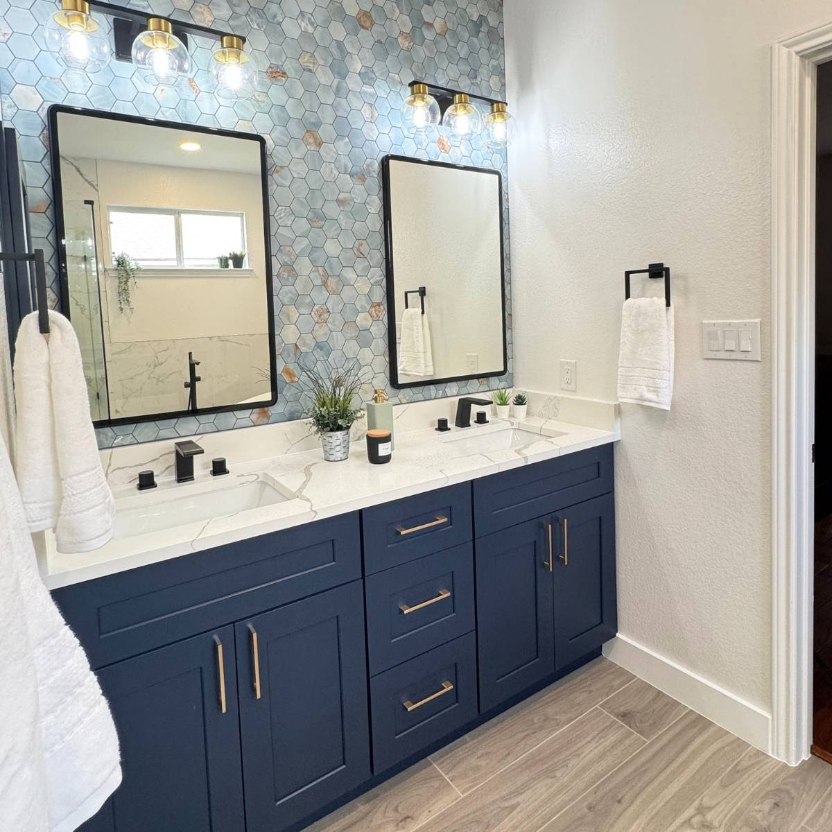 Luxury primary bathroom after renovation with custom tile, statement mirrors and lighting in Austin