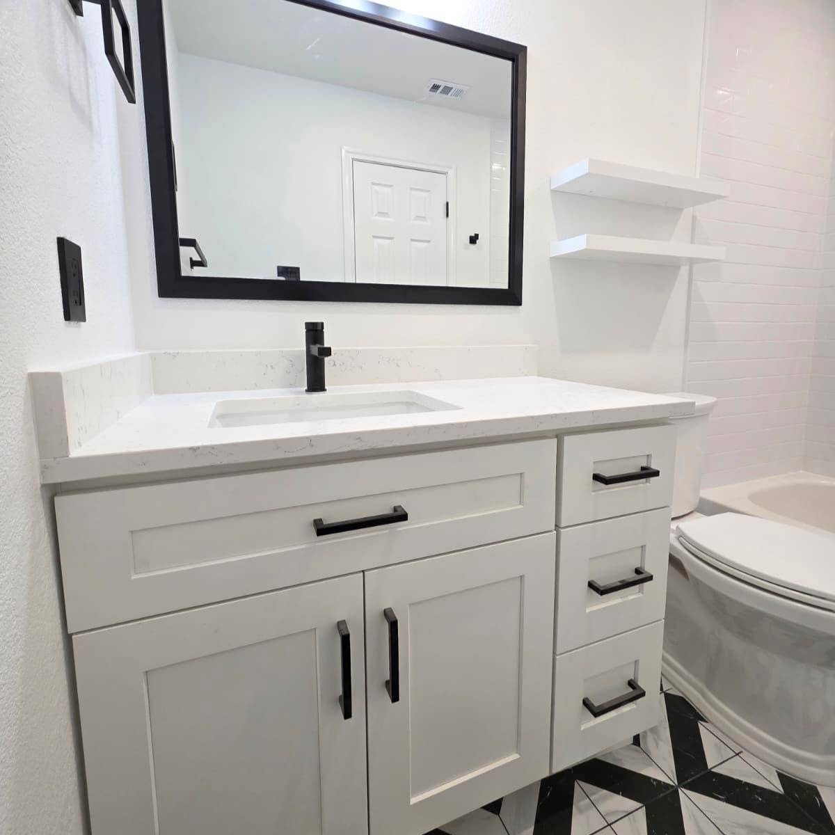 Contemporary bright bathroom after remodel featuring white tile and black fixtures