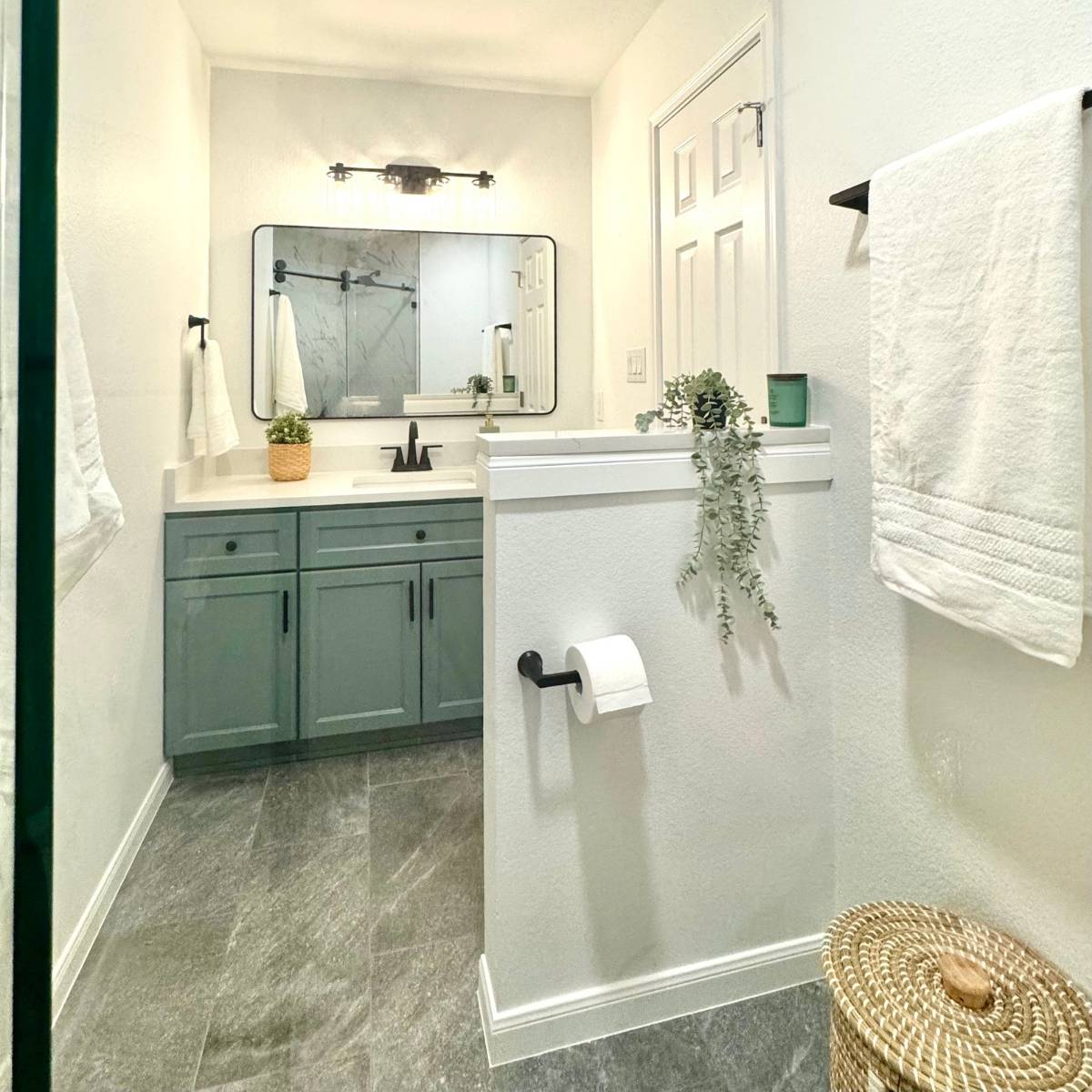 Bright bathroom after remodel with new vanity, stone countertop, and custom lighting