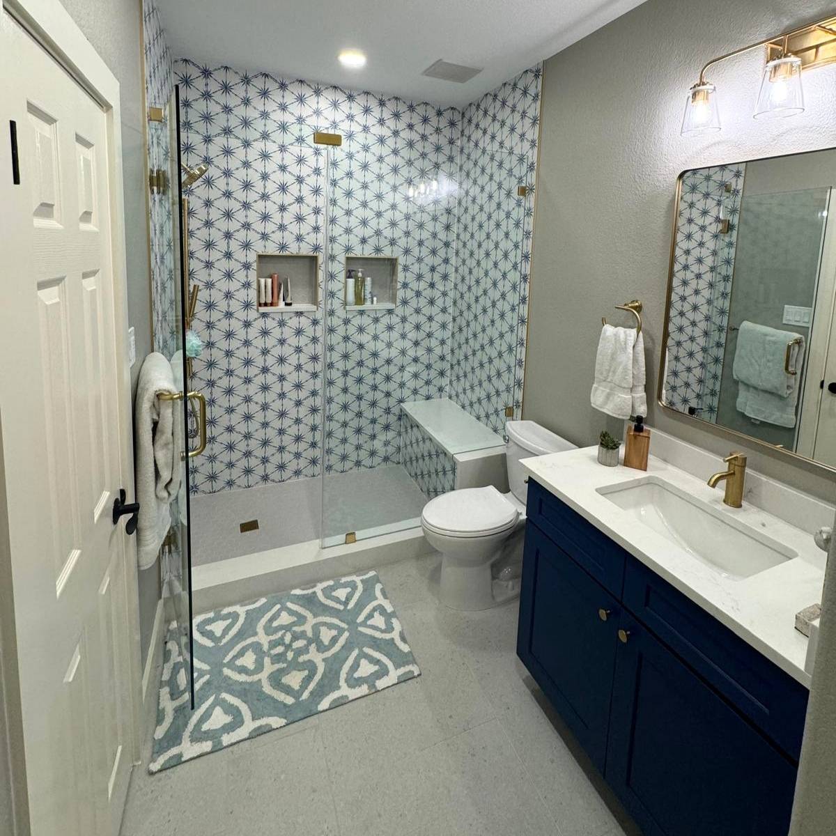 Modern bathroom  with blue cabinets and custom tile shower after Jack & Jill remodel in Austin