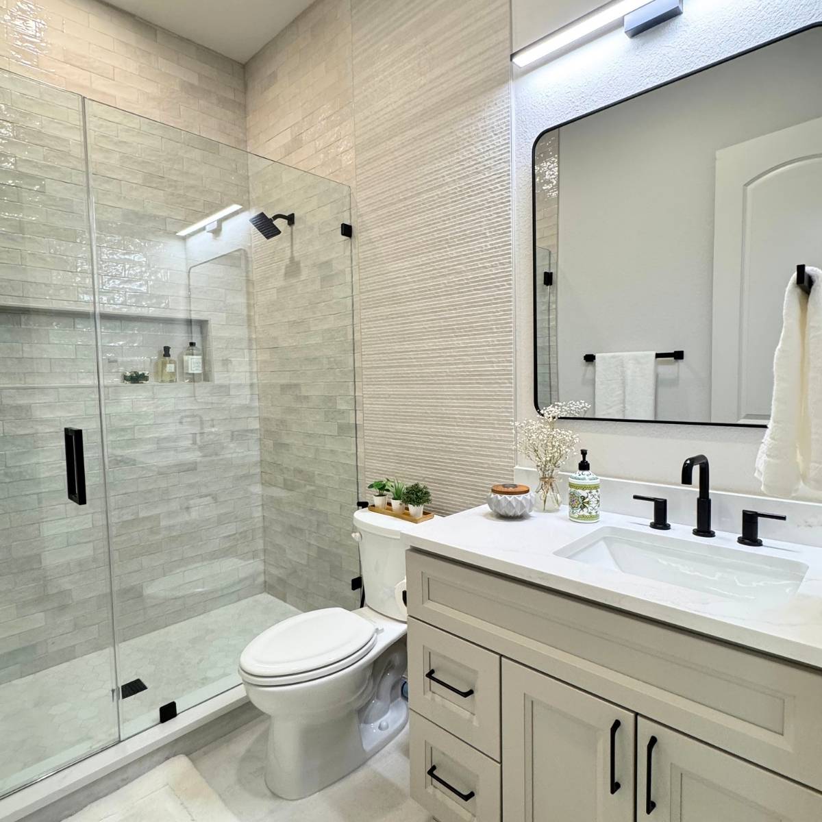 Updated bathroom from Jack and Jill setup with new vanity, mirror, and statement lighting & fixtures