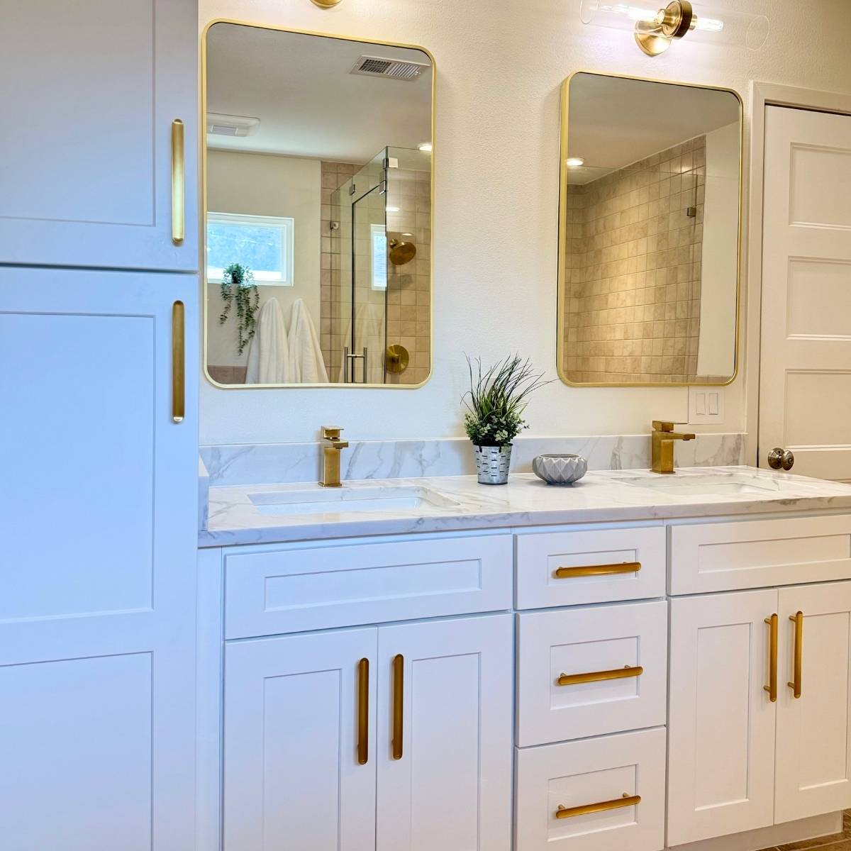After: remodeled bathroom with new light vanity, modern mirrors, and statement lighting