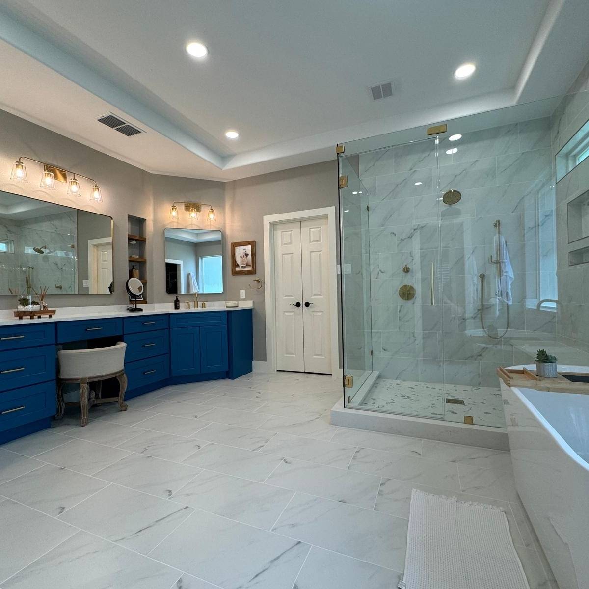 Luxury Austin primary bathroom suite after renovation with freestanding tub, modern tile floor and walk-in shower