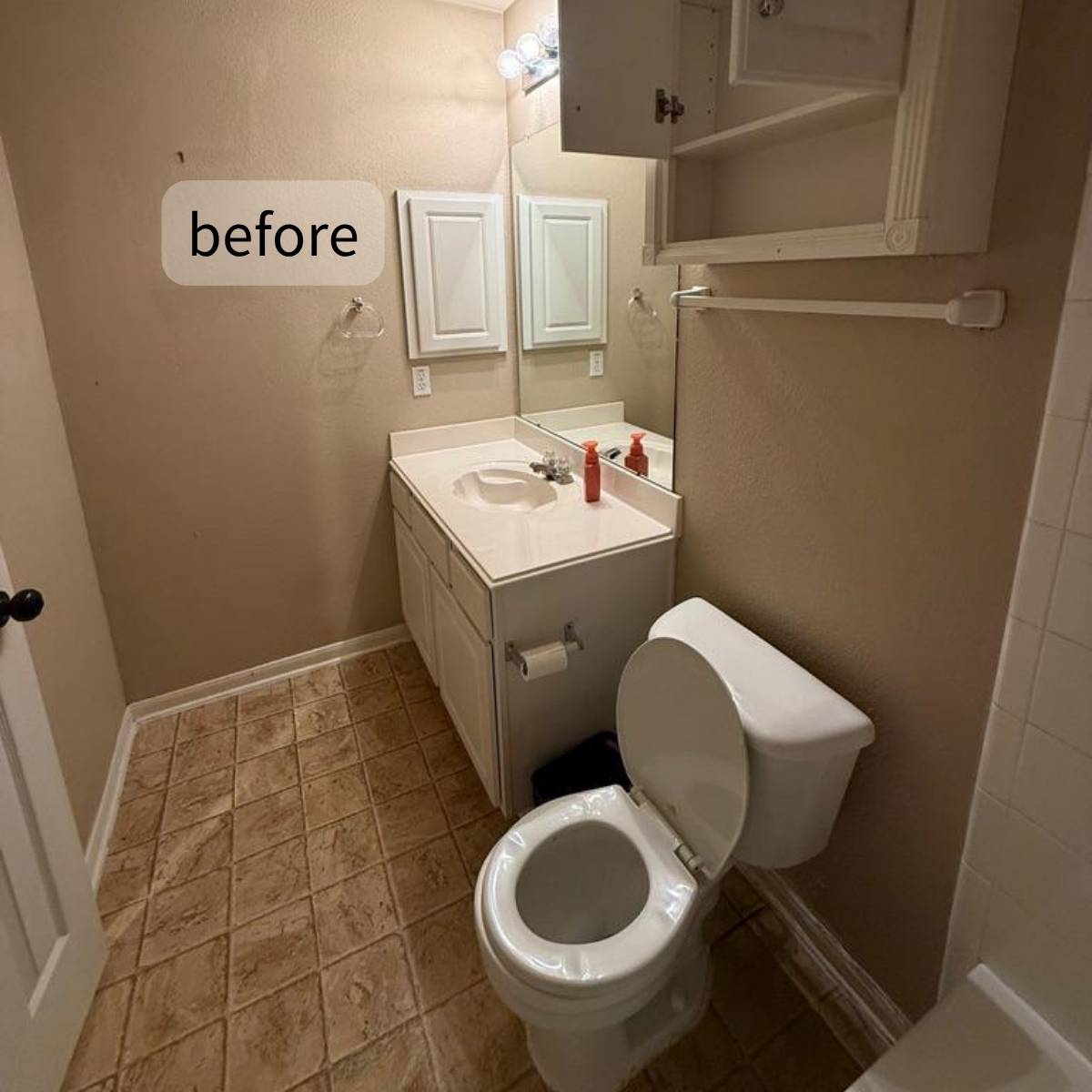 Bathroom before renovation with dim lighting and beige tile