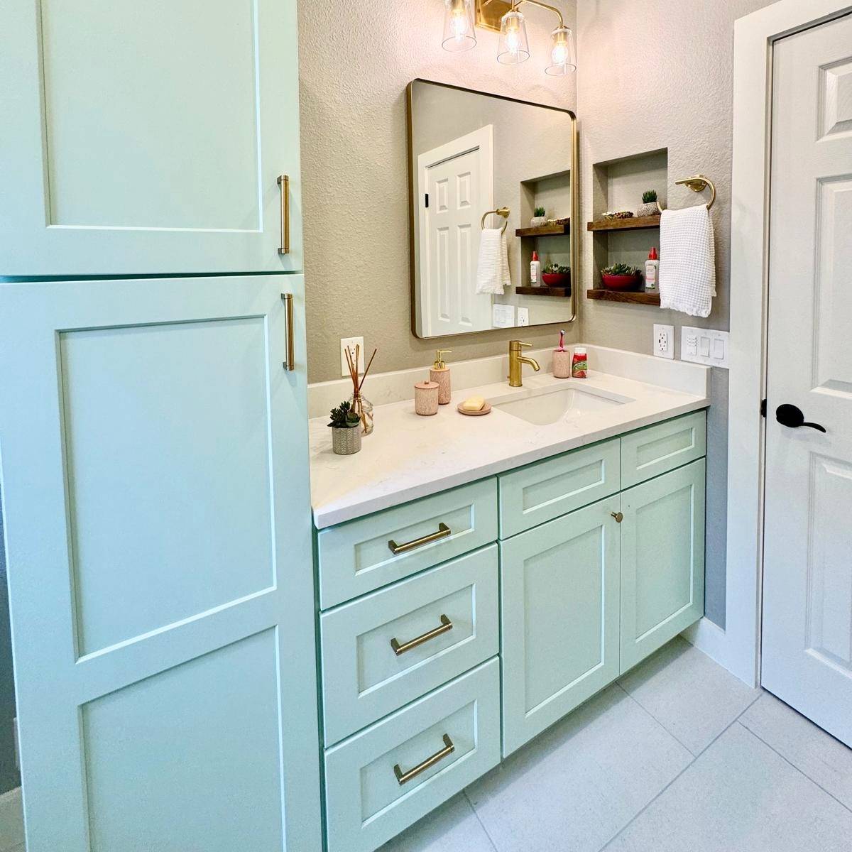 Bright bathroom after Jack & Jill makeover with new custom vanity, stone countertop, and gold fixtures