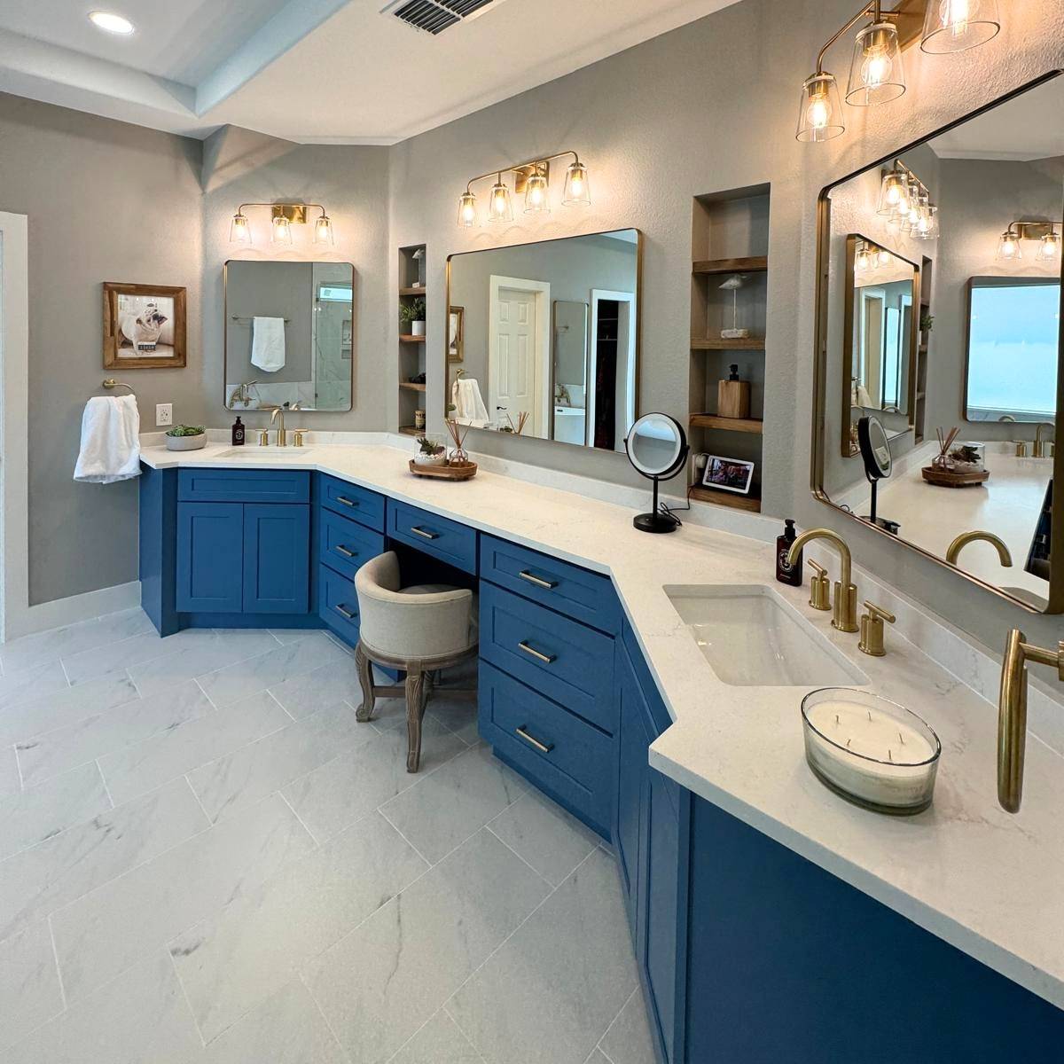 Primary bathroom remodel with custom blue cabinets and gold statement fixtures