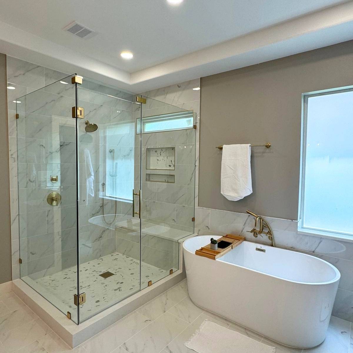 Luxury primary bathroom after renovation with freestanding tub and custom walk-in shower in Austin