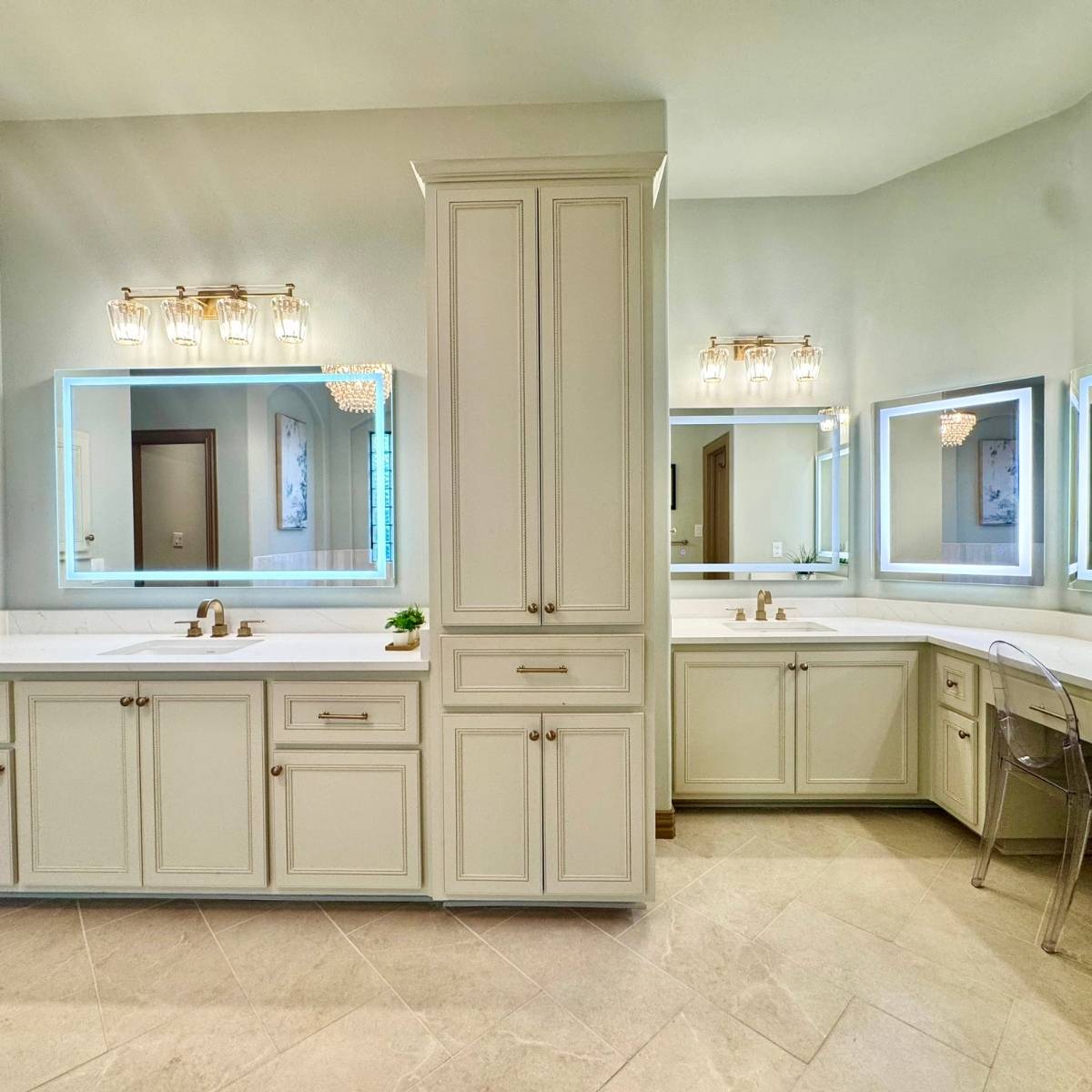 Luxury primary bathroom after renovation with custom cabinets with modern hardware and lit mirrors in Austin