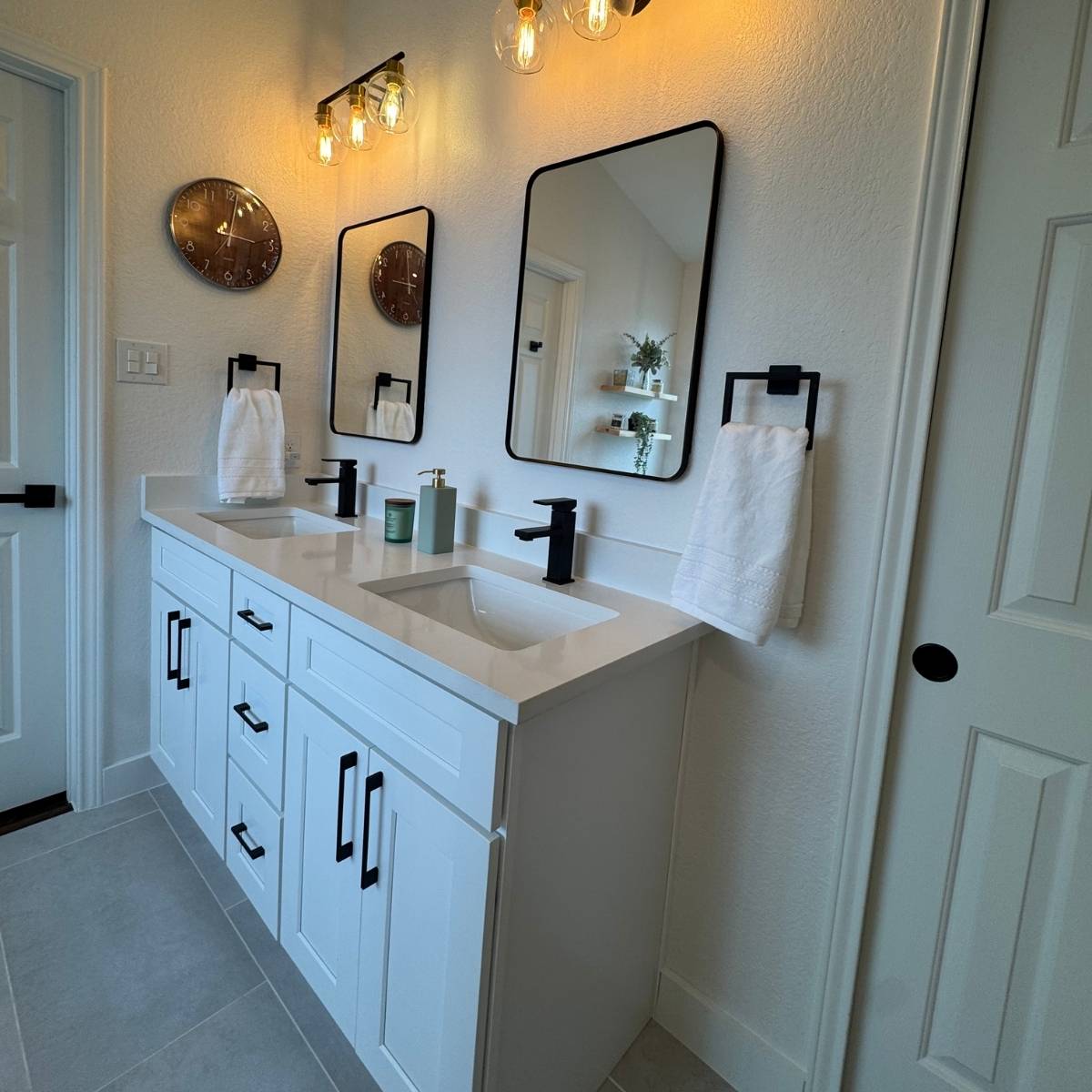 Modern white bathroom after remodel with double vanity and quartz countertops in Austin