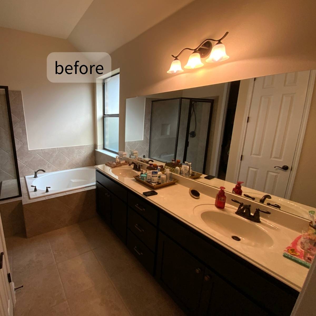 aging bathroom before renovation in Austin TX with dated vanity and bath/shower combo