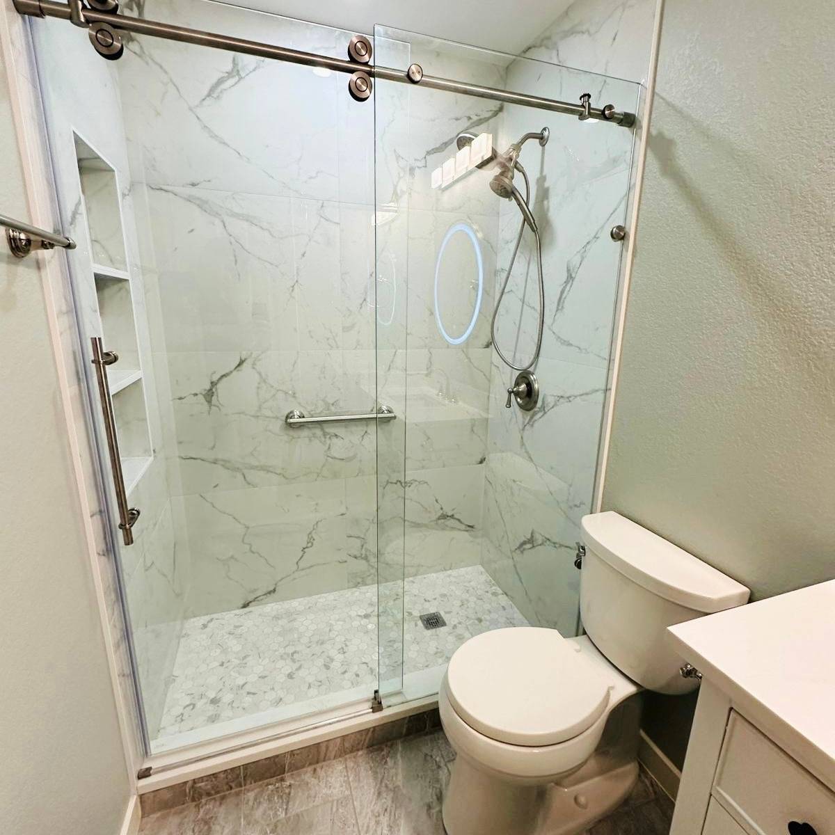 Luxury bathroom after renovation with custom-tiled walk-in shower in Austin
