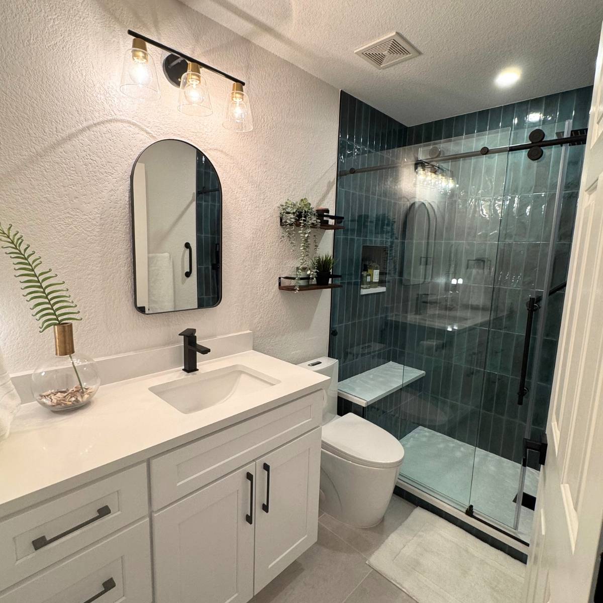 bathroom remodel after photo Austin Texas with bright vanity and walls and black modern fixtures with a statement walk-in shower