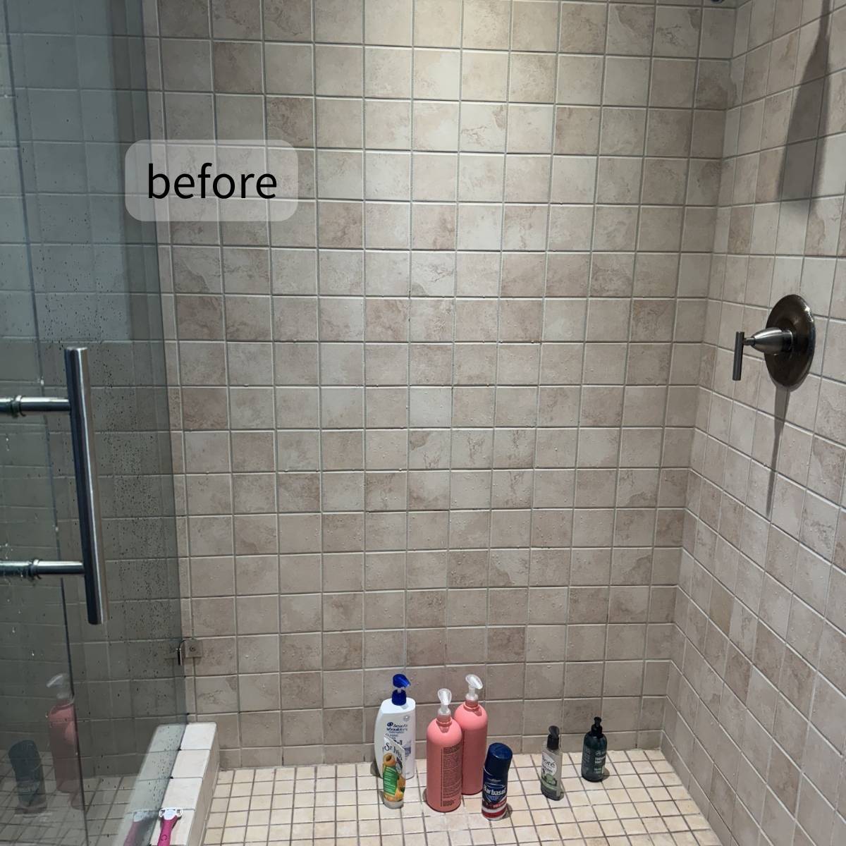 Primary shower before makeover dark tile and basic fixtures
