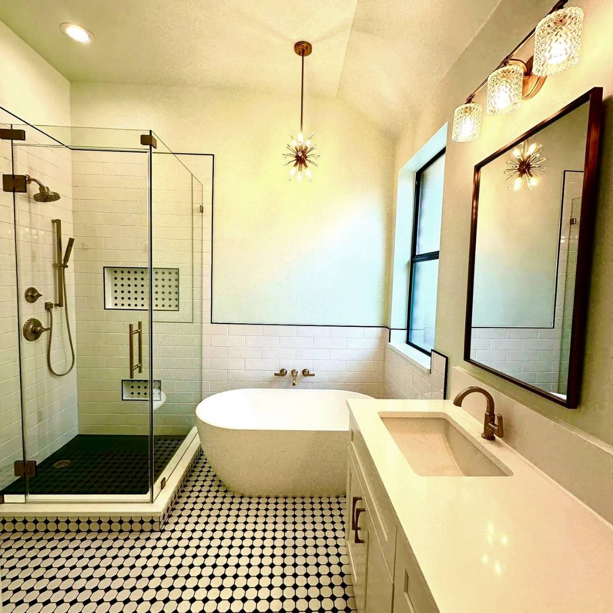 custom bathroom renovation in Austin TX with glass shower, custom black & white tile design and statement lighting