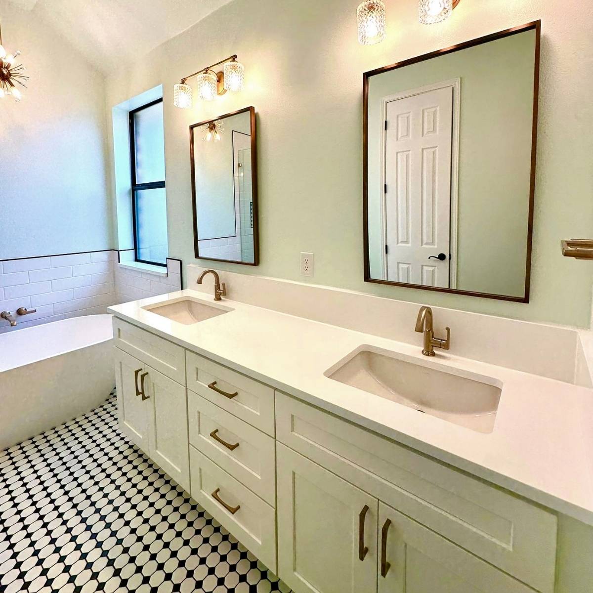custom bathroom renovation in Austin TX with glass shower, custom black & white tile design and statement lighting