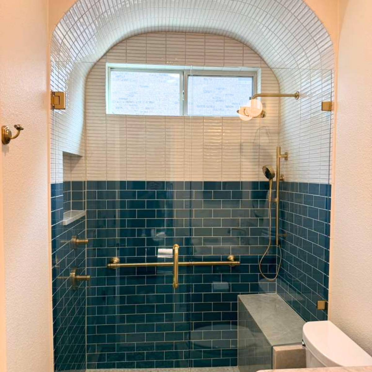Custom arched tile shower and gold fixtures in Austin bath remodel