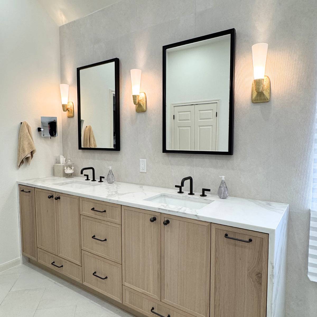 Luxury primary bathroom remodel in Cedar Park TX featuring a custom white oak vanity, quartz countertops, matte black fixtures, and light porcelain tile by ATX Custom Remodel.