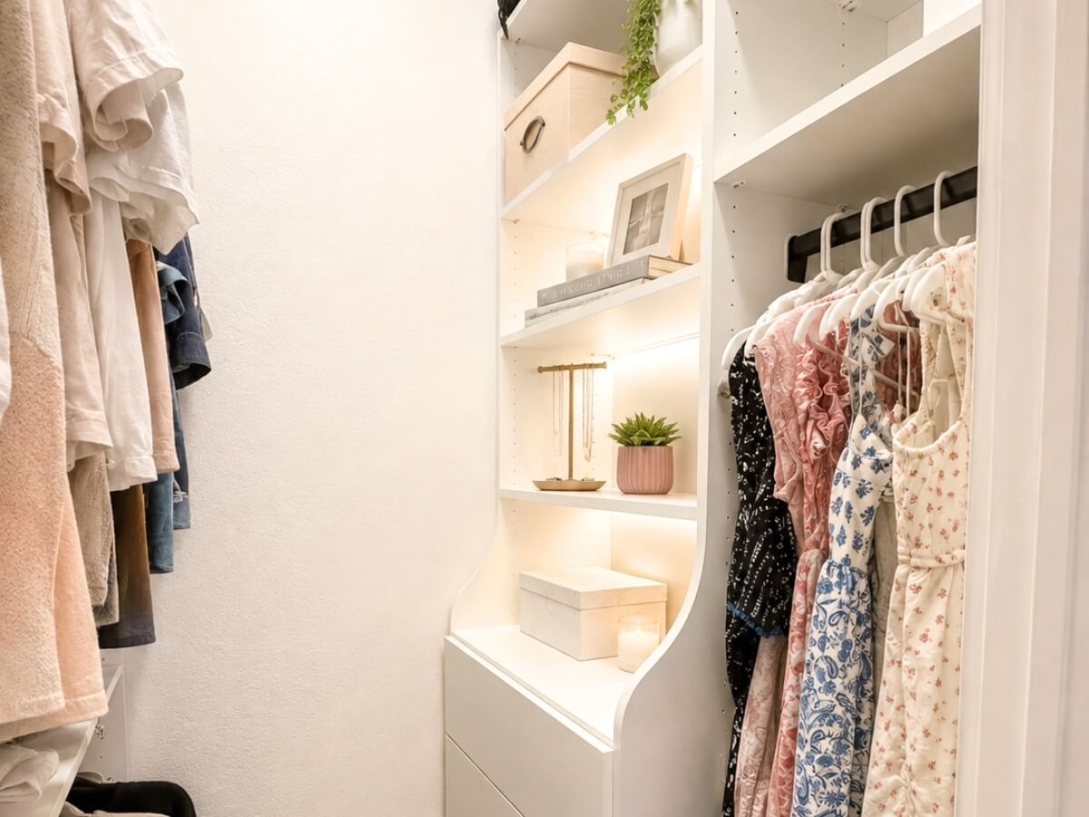 Custom walk-in closet organization system with built-in drawers, LED shelving, and dress hanging rods.