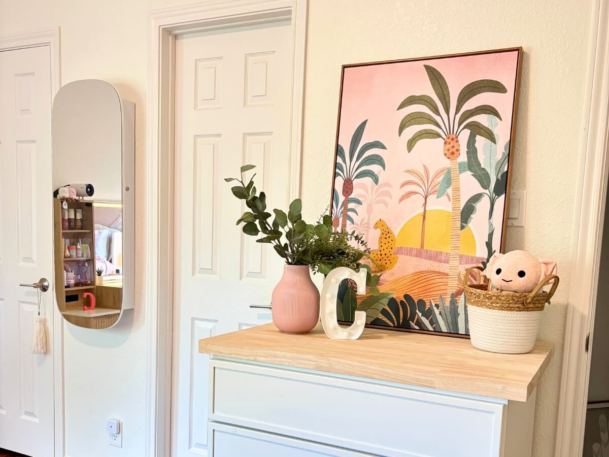Modern white dresser with wood top and pink tropical artwork in a Round Rock teen bedroom remodel.