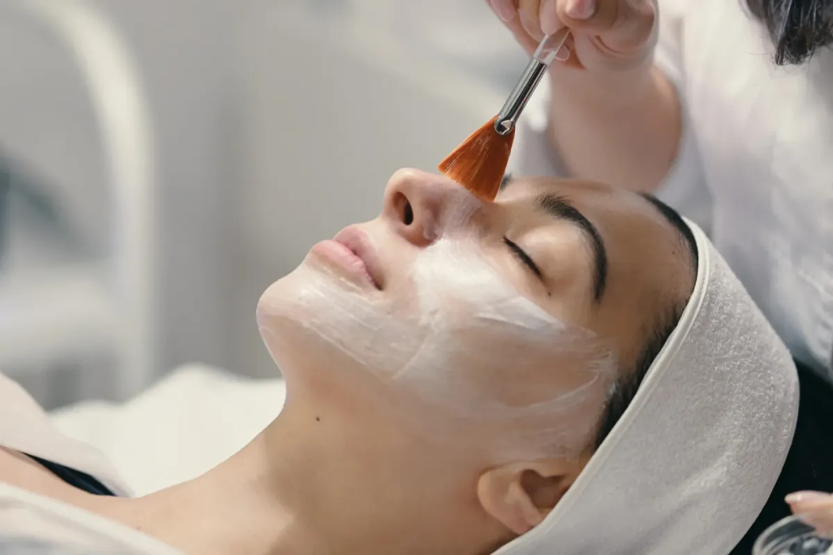 woman putting makeup in front of mirror