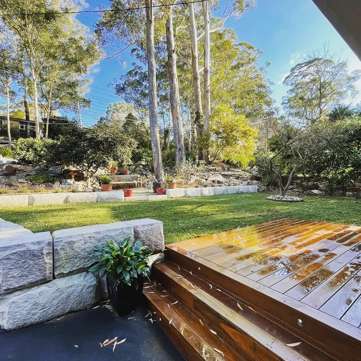 Hardwood timber deck meeting sandstone steps and lawn