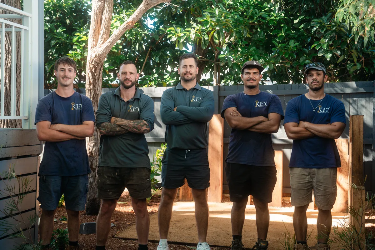 The Key Landscaping crew standing together in front of a finished timber screen