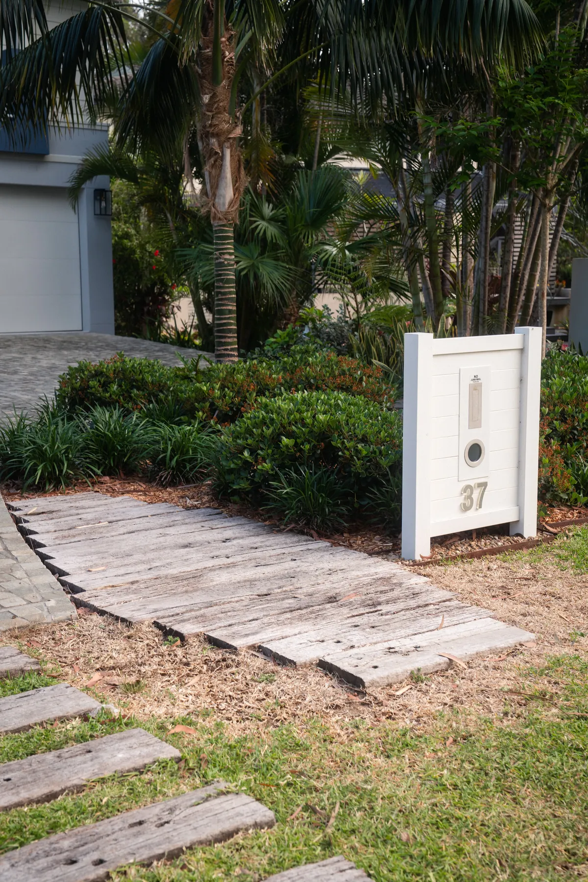 Sandstone path and letterbox set into lush front garden