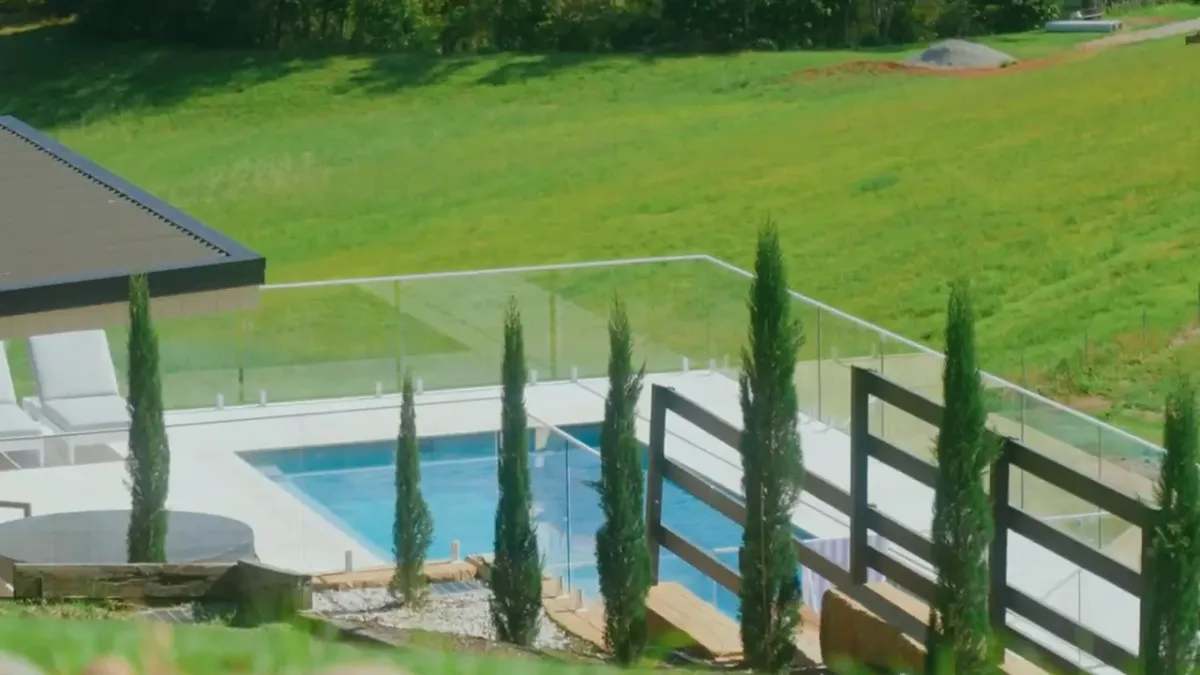 Drone footage gliding over a terraced Key Landscaping garden in Picketts Valley with cypress-lined fences and native planting