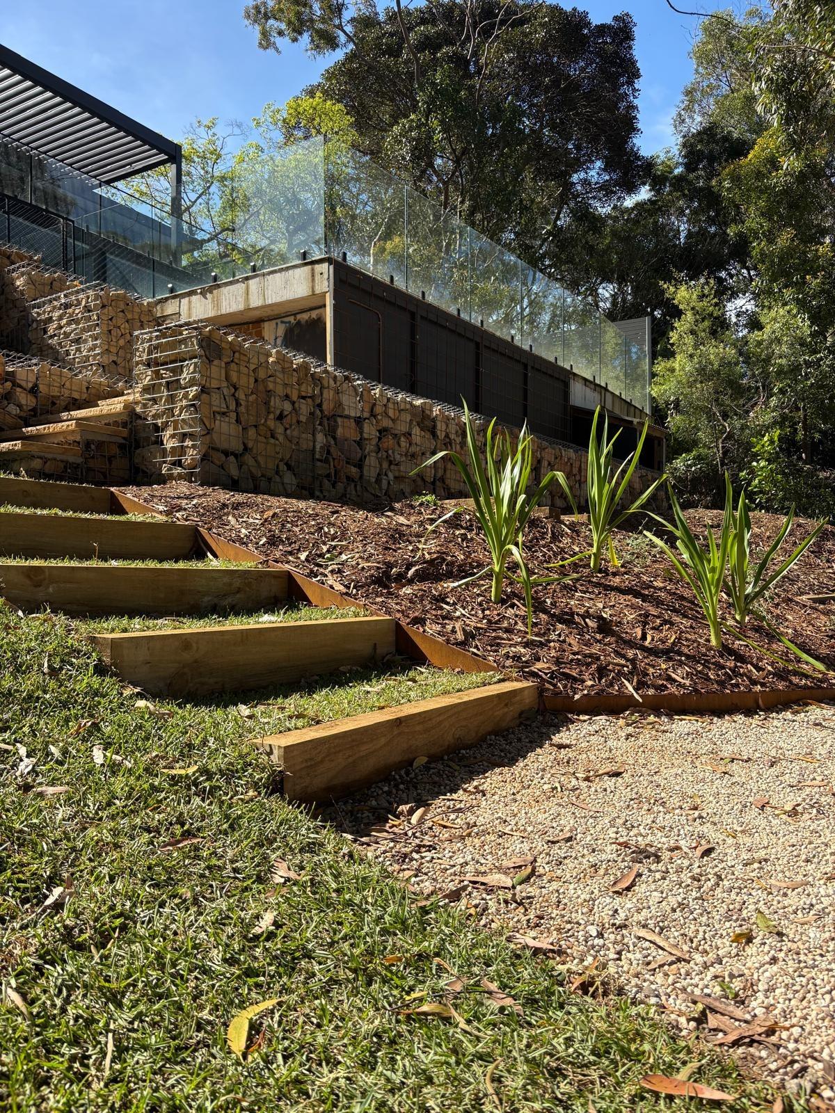 Timber sleeper steps and corten edging below gabion walls