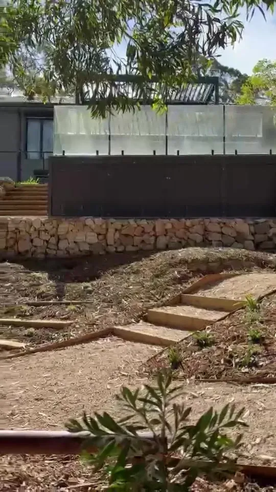Video still of a bushland garden with gabion terraces and gravel paths