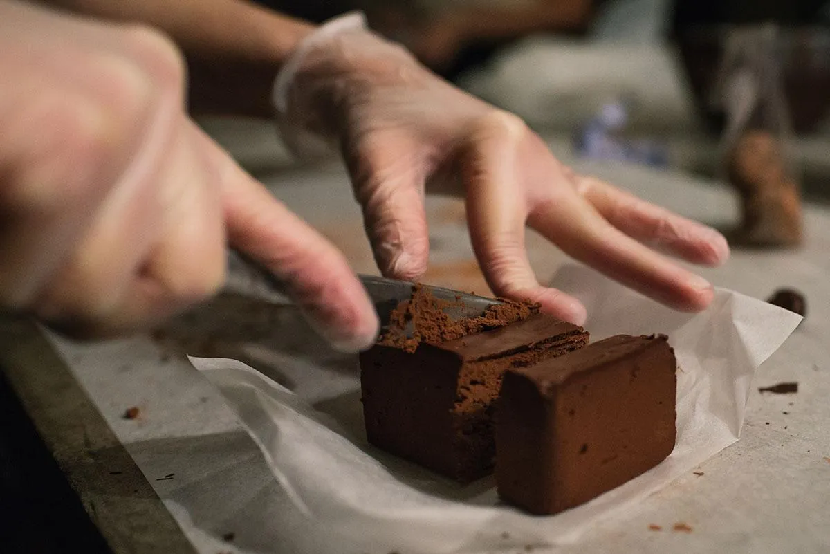 pair of gold-colored earrings on table and black ankle-strap pumps on area rug