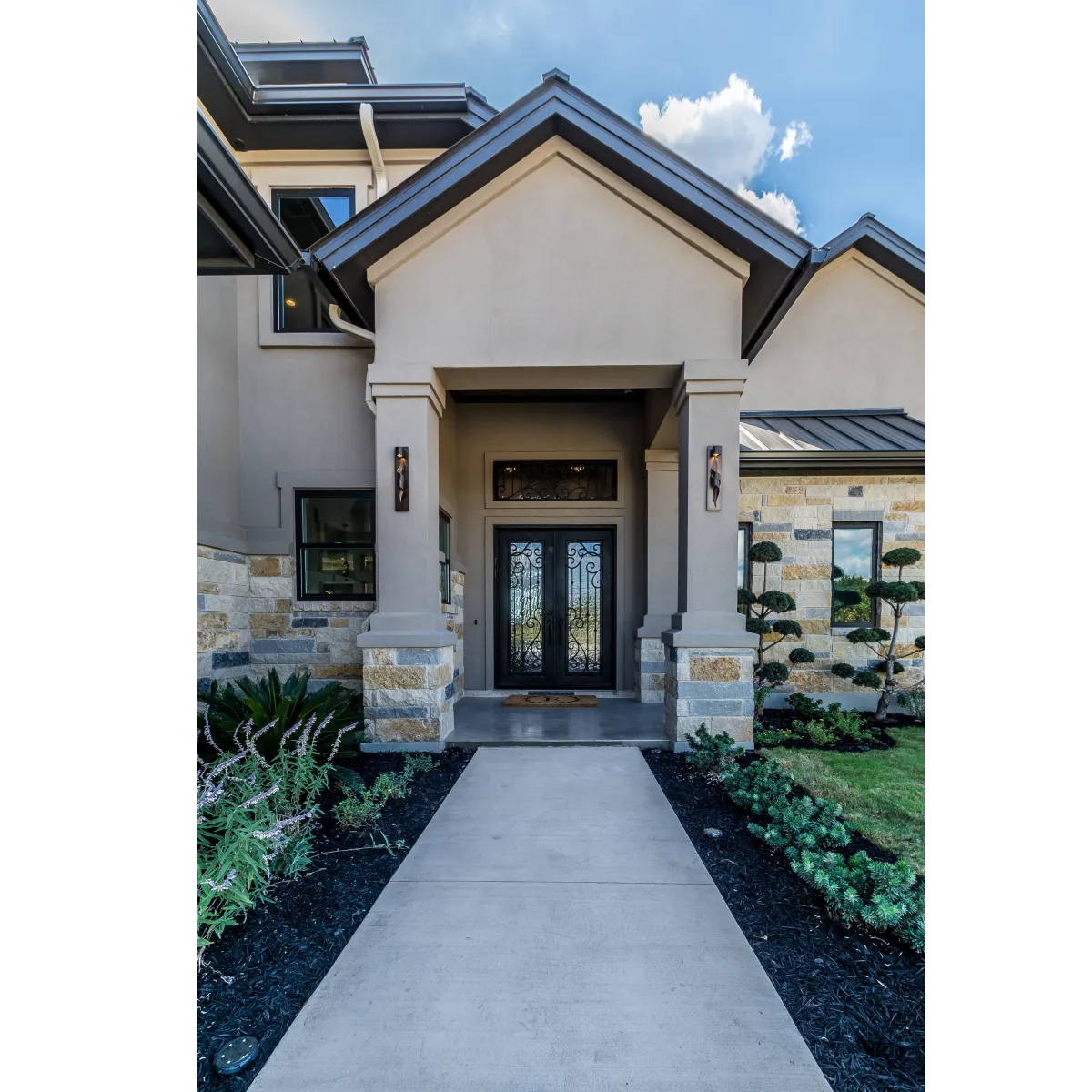 house with two columns and brown stucco