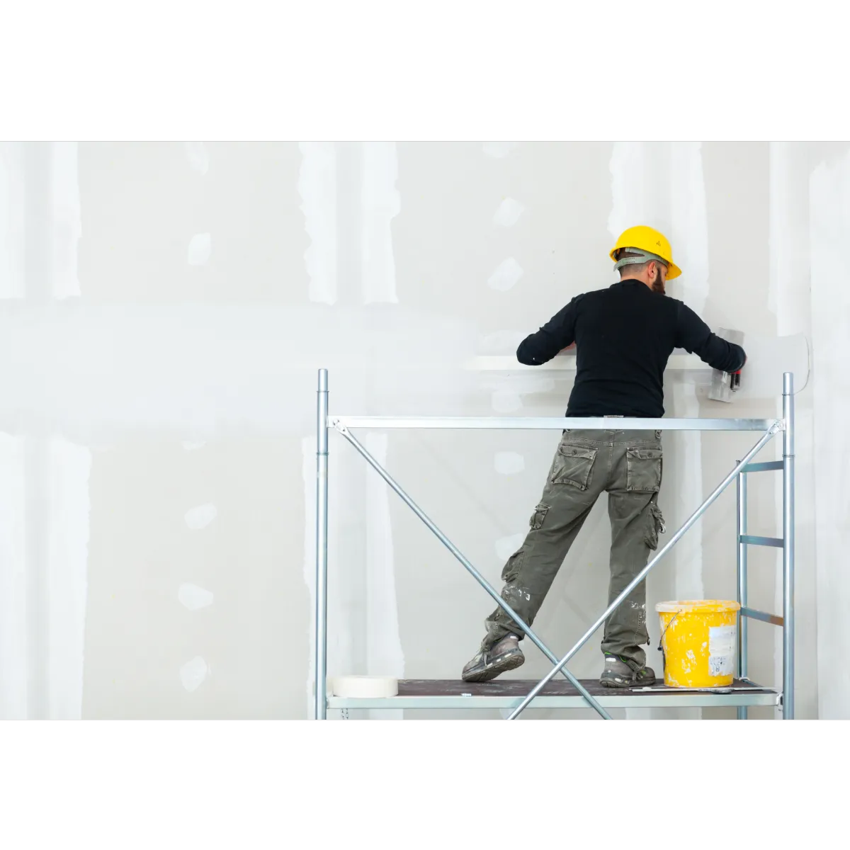 Man on ladder applying stucco