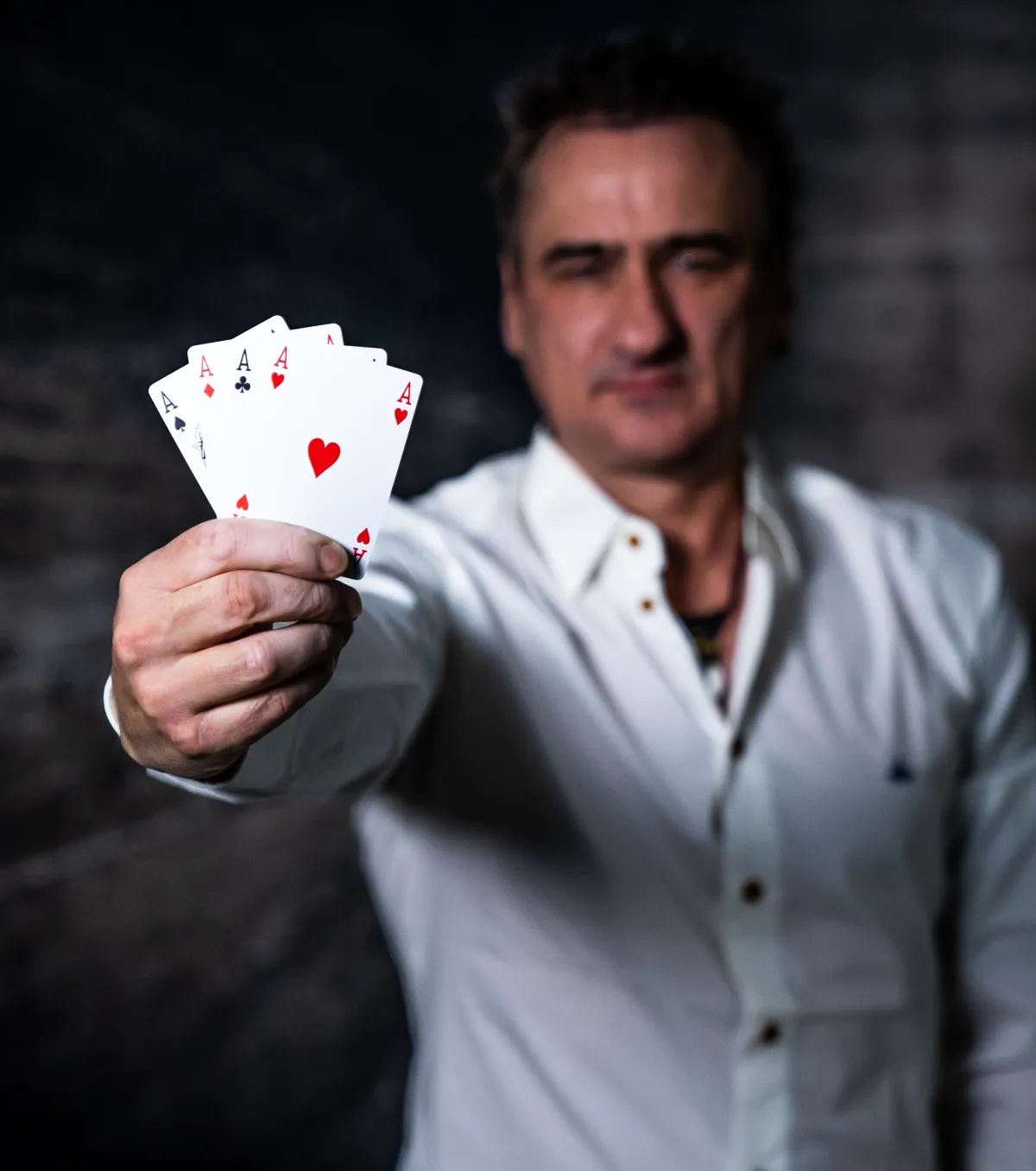 Ralp Dittmar wie er Pokerkarten in die Kamera zeigt