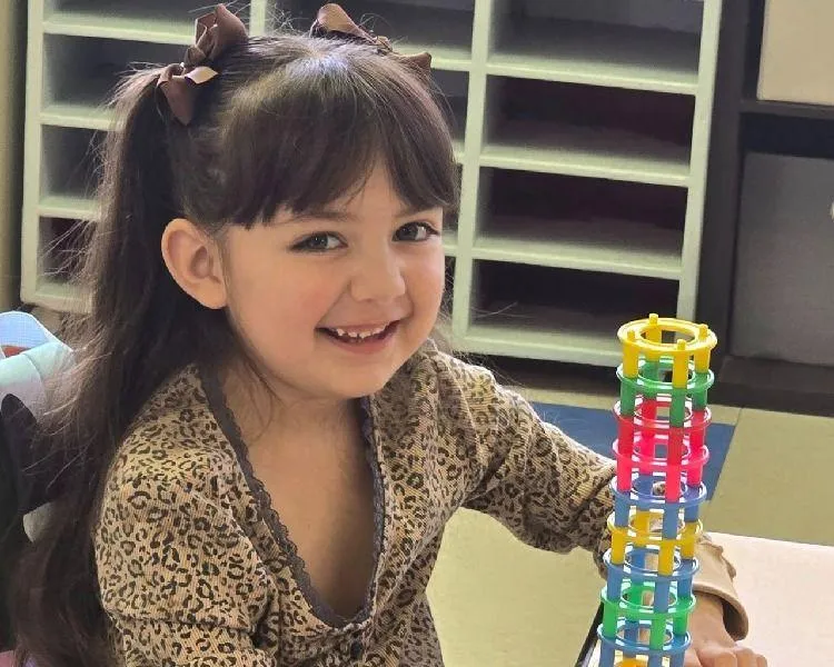 Girl watches a lesson about the alphabet on a laptop